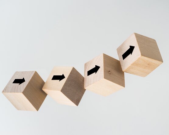 Fünf Holzwürfel mit Pfeilen drauf